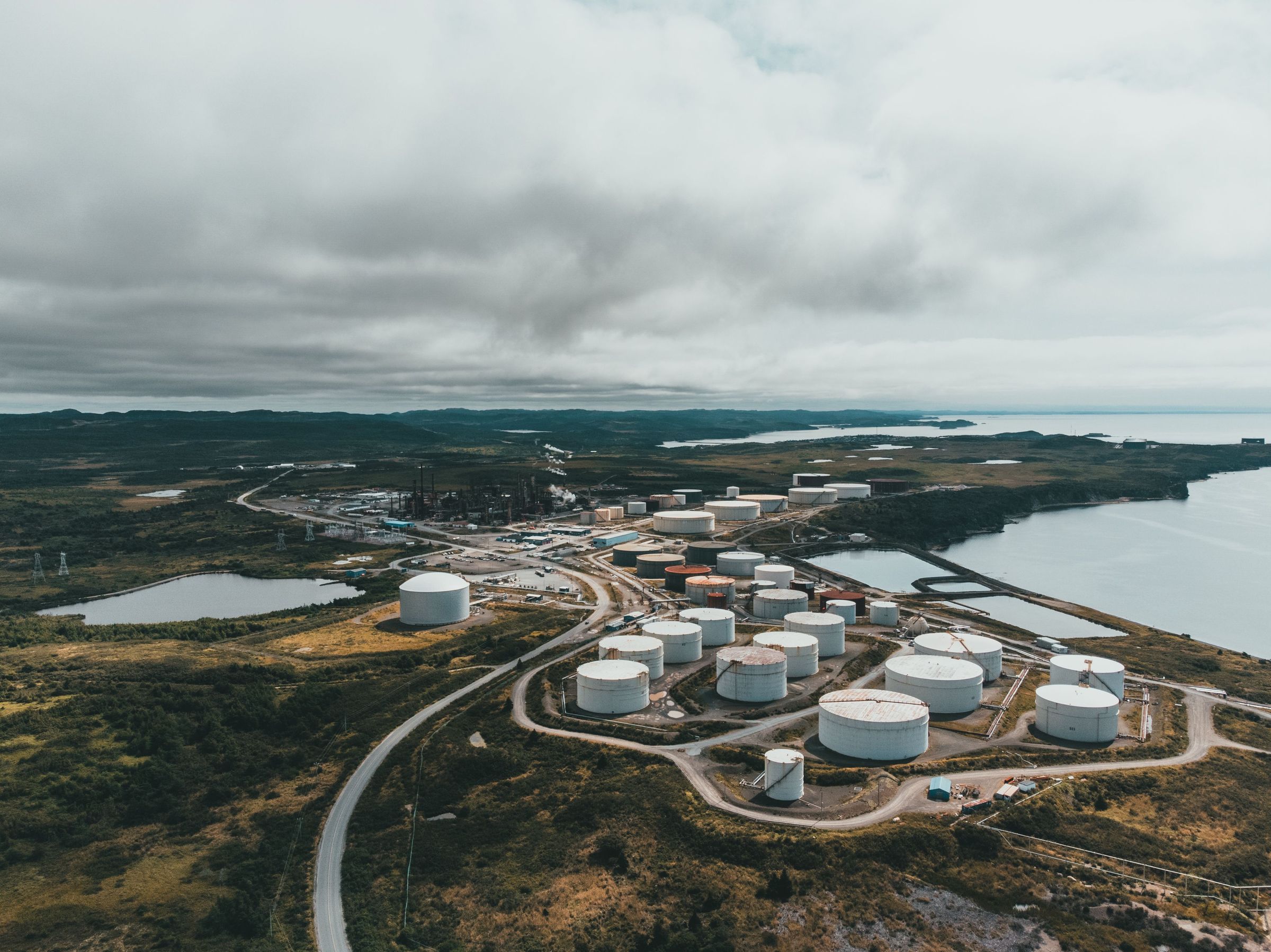 A coastal fuel terminal from the air, its storage tanks set along the shore